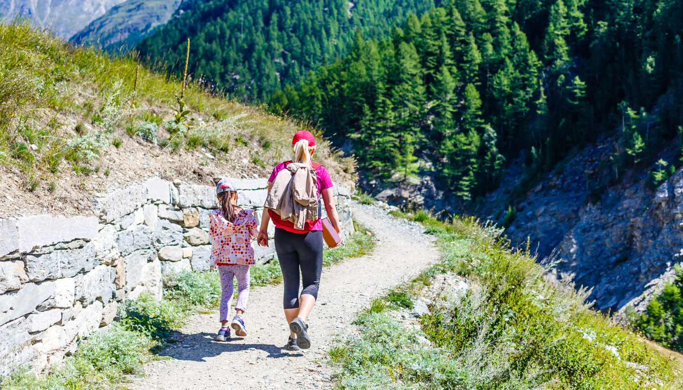 Mutter und Tocher wandern entlang einer Natursteinmauer